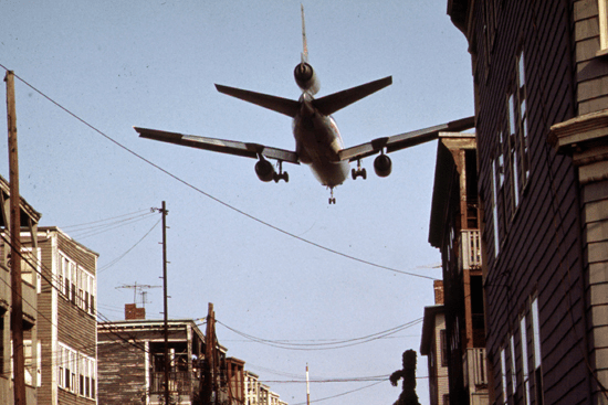 image Here is a picture of a plane flying low over a crowded city street.